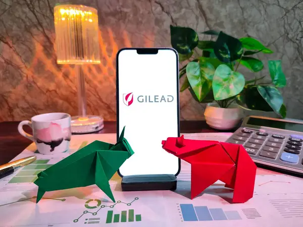 NewYork, USA- 15 Aralık 2024: GILEAD Borsa Analizi üzerine Seçici Odaklanma Grafikler, grafikler, hesap makinesi ve kahve içeren finansal içgörü için GILEAD Inc logosu ile akıllı telefon