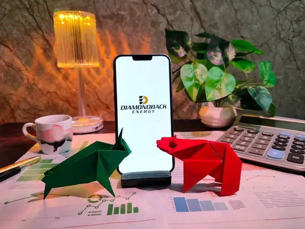 New York, ABD - 15 Aralık 2024: DiAMONDback ENERGY borsa analizi üzerine seçici odaklanma grafikler, grafikler, hesap makinesi ve kahvenin yer aldığı bir akıllı telefon üzerinde finansal içgörü için DIAMONDback ENERGY Inc logosu
