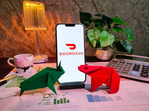NewYork, ABD - 15 Aralık 2024: Finansal içgörüler için bir akıllı telefon üzerinde DOORDASH Inc logosu bulunan grafikler, grafikler, hesap makinesi ve kahvenin yer aldığı DOORDASH Inc.