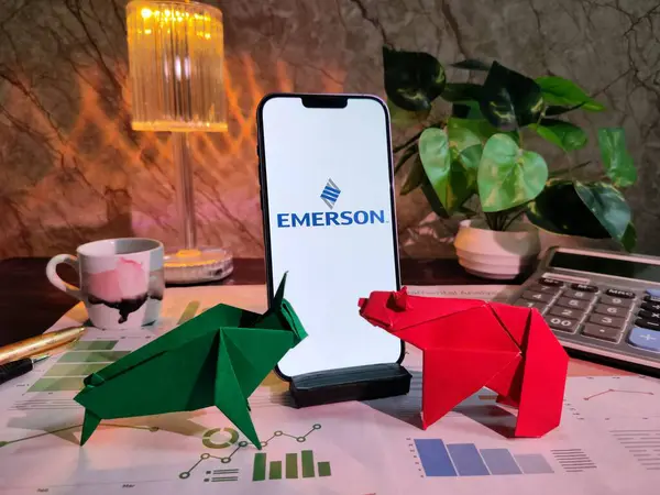 New York, USA- 15 Aralık 2024: EMERSON borsa analizi üzerine seçici odaklanma grafikler, grafikler, hesap makinesi ve kahve içeren finansal içgörü için EMERSON Inc logosu ile akıllı telefon