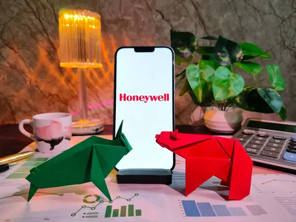 New York, ABD - 15 Aralık 2024: HONEYwell Inc. 'in finansal görüşler için akıllı bir telefon üzerinde grafikler, grafikler, hesap makinesi ve kahvenin yer aldığı borsa analizi üzerine seçici odaklanma
