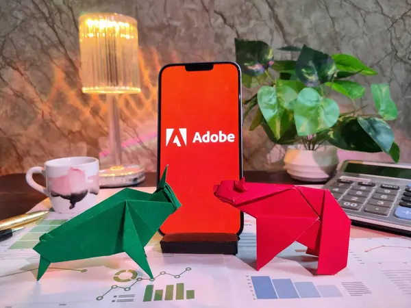 New York, USA- 15 Aralık 2024: Finansal içgörüler için akıllı bir telefonda grafikler, grafikler, hesap makinesi ve kahvenin yer aldığı ADOBE Inc.