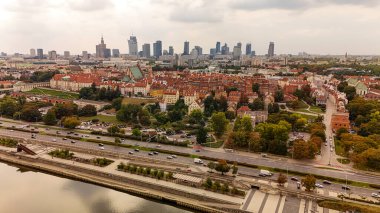 Varşova 'nın Eski Şehir ve modern şehir siluetinin panoramik bir görüntüsü. Görüntü, tarihi mimariyle bulutlu bir gökyüzü altındaki çağdaş binalar arasındaki zıtlığı gösteriyor..