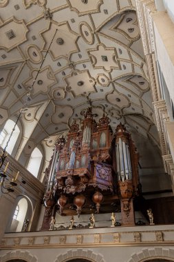 Tarihi bir kilisede bulunan bu süslü boru orgun güzelliğini keşfedin. Tonozlu tavan ve karmaşık ahşap oymalar ihtişamı artırıyor. Bu da mimari ve müzik tutkunlarının görmesi gereken bir şey..