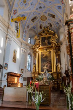 Süslü bir altın sunak, mavi ve altın tasarımlar ve dini sanat eserleriyle dolu kubbeli bir barok kilisesinin iç yüzünü keşfedin. Dini sanat ve mimariyle ilgilenenler için mükemmel..