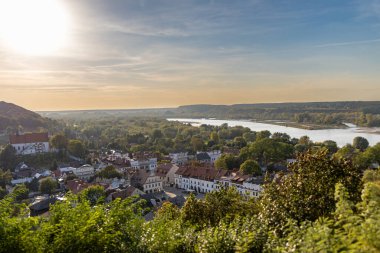 Polonya 'nın Kazimierz Dolny kentinin panoramik manzarası, Vistula Nehri' nin doğuşu sırasında ve kasabanın tarihi mimarisi yemyeşil bir alana yerleşmiştir. Kırsal ve nehrin huzurlu, manzaralı bir manzarası..