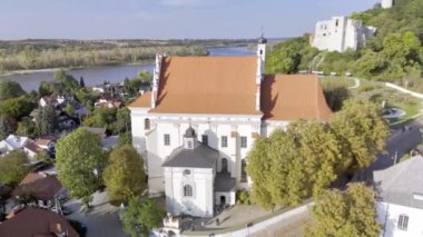 Polonya 'nın Kazimierz Dolny kentindeki güzel tarihi kilise ve ortaçağ şatosunu Vistula Nehri manzaralı bir manzarayla yakalayan insansız hava aracı. Seyahat, tarih ve mimariyle ilgili içerik için mükemmel.