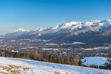 Polonya 'nın Zakopane kentinin göz kamaştırıcı kış manzarasında, gün batımında karla kaplı Tatra Dağları yer alıyor. Orman ve tepelerle çevrili pitoresk dağlık kasaba nefes kesici manzaralar sunuyor ve kayak, yürüyüş ve turizm için popüler bir yer. 