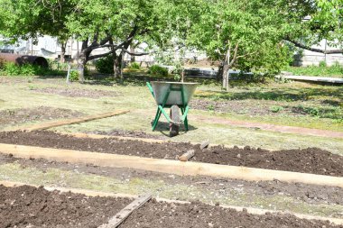 Bahçe yatakları verimli toprak ve gübrelerle doldurulmak için çitlerle çevrili, sebze ve yaprak tohumu ekmek için..