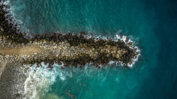 stock image Aerial view of a rock breakwater on the blue Caribbean Sea coast