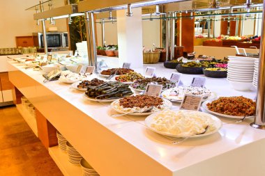 Açık büfe masasında geniş bir tabak seti.