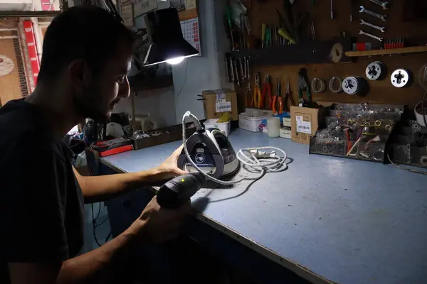 Atölyede çalışan bir işçi, motosiklet üzerinde çalışıyor.