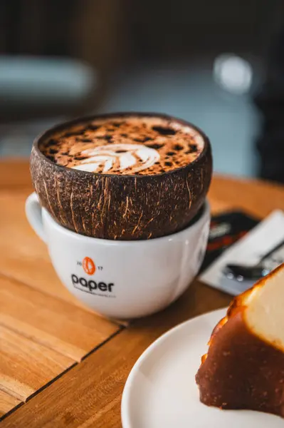 Bir kahve fincanı ve sabah tahta bir masanın üzerinde çikolata.