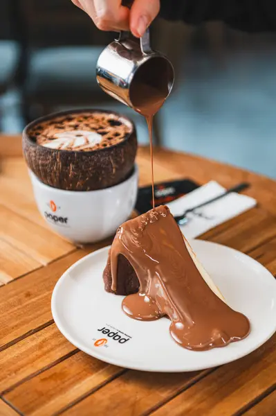 Çikolatalı kekin yakın plan fotoğrafı ve masada bir fincan kahve.