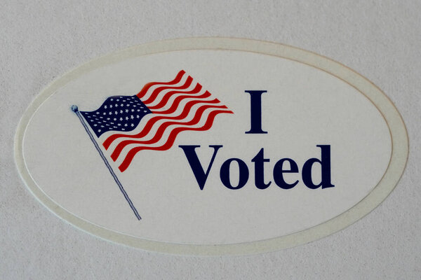 "I Voted "Наклейка с американским флагом на бумаге.  