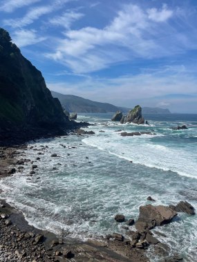 Mavi gökyüzü ve mavi sularıyla bir uçurum / dağın kıyısında kayalık bir sahil. San Juan de Gaztelugatxe tarafından çekilen, Dragonstone 'un popüler dizisi Game of Thrones' un çekimleri İspanya 'nın Bask Sahili açıklarında..