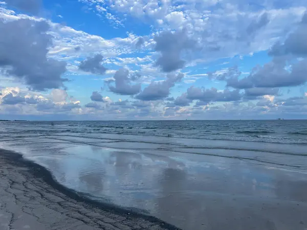 Stock image Gorgeous ocean view off the Gulf coast of Alabama. Blue sky full of pretty clouds reflecting in the shine of the wet sand