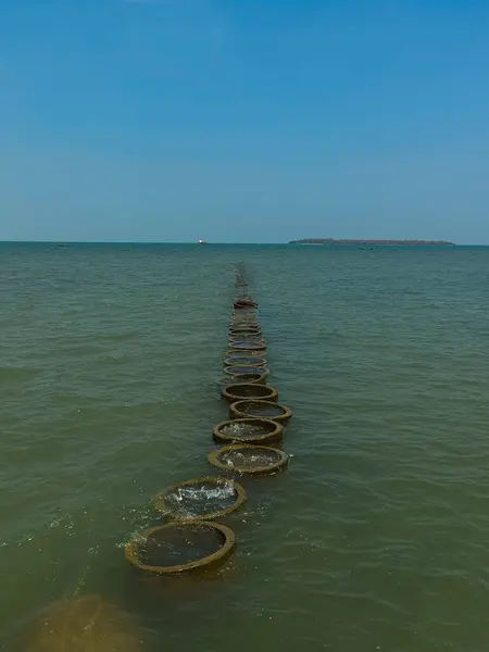 stock image Manmade Pathway of Circular Structures Leading Far into the Sea with Endless Horizon