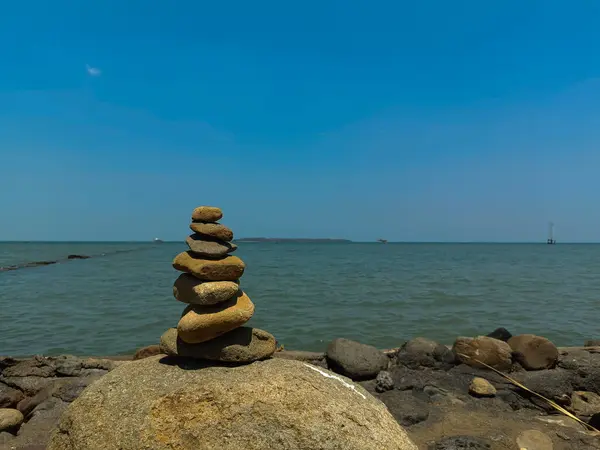 stock image Balanced Stone Cairn by the Sea Reflecting Tranquility in a Calm Coastal Landscape