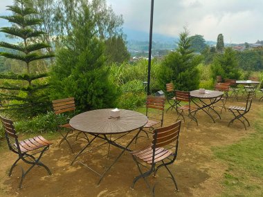 Multiple Garden Tables and Chairs in Scenic Outdoor Restaurant Setting clipart