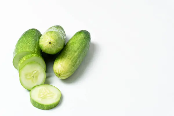 Taze yeşil salatalık ve salatalık. Beyaz arka planda düzenlenmiş ve biçilmiş. Salatalıklar K vitamini, C vitamini, potasyum ve magnezyum gibi önemli vitamin ve mineraller içerir..