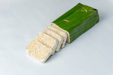 Endonezya Tempe 'si ya da mayalanmış soya fasulyesi. Muz yapraklarıyla kaplı mayalanmış soya fasulyesinin geleneksel yiyeceği. Geleneksel Endonezya Tempe Çanağı. Taze Tempeh Hazır