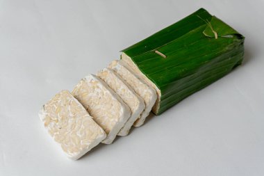 Endonezya Tempe 'si ya da mayalanmış soya fasulyesi. Muz yapraklarıyla kaplı mayalanmış soya fasulyesinin geleneksel yiyeceği. Geleneksel Endonezya Tempe Çanağı. Taze Tempeh Hazır