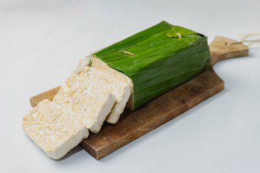 Endonezya Tempe 'si ya da mayalanmış soya fasulyesi. Muz yapraklarıyla kaplı mayalanmış soya fasulyesinin geleneksel yiyeceği. Geleneksel Endonezya Tempe Çanağı. Taze Tempeh Hazır