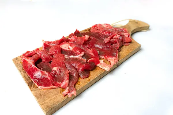 stock image Sliced fresh raw beef served   on cutting board isolated on white background