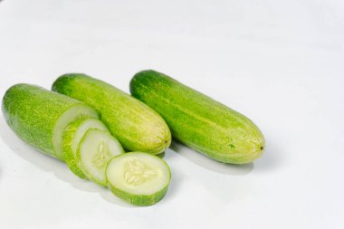 Taze yeşil salatalık ve salatalık. Beyaz arka planda düzenlenmiş ve biçilmiş. Salatalıklar K vitamini, C vitamini, potasyum ve magnezyum gibi önemli vitamin ve mineraller içerir..