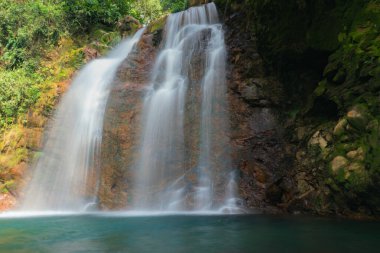 Güzel bir şelalenin yosunların üzerine düşmesi kayalarla kaplı sakin bir su havuzuna dönüşür ve yavaş bir deklanşör tekniği suya ruhani bir etki yapar..