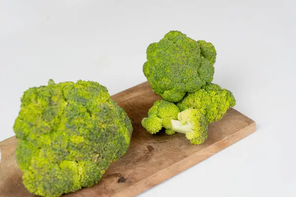 Beyaz arka planda izole edilmiş kesme tahtasındaki taze çiğ Brokolli lahana. Sağlıklı gıda konsepti. protein sebze konsepti.