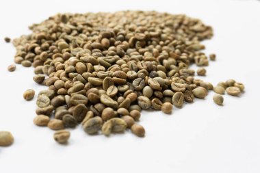 Beyaz arka planda kavrulmuş yeşil kahve çekirdekleri yakın plan..