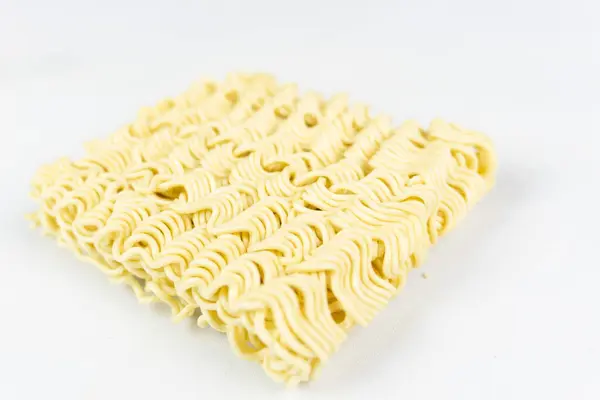 Sarı çiğ erişte ya da beyaz arka planda kurutulmuş erişte.