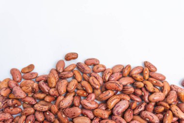 Pişmemiş kırmızı organik sağlıklı fasulye tohumlarının beyaz izole bir arka planda bir kasede üst görüntüsü. Sağlıklı gıda konsepti