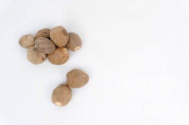 Nutmeg 'i kapatın ve Hindistan cevizi yığınını beyaz arka planda izole edin. Bitki ve baharat konsepti.