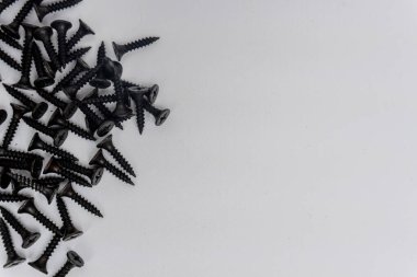 Beyaz arkaplanda izole edilmiş yapı malzemeleri için siyah cıvatalar ve vida yığınları
