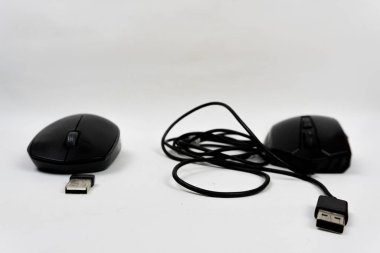 İki siyah bilgisayar faresi, biri kablosuz, beyaz arka planda alıcıları var.
