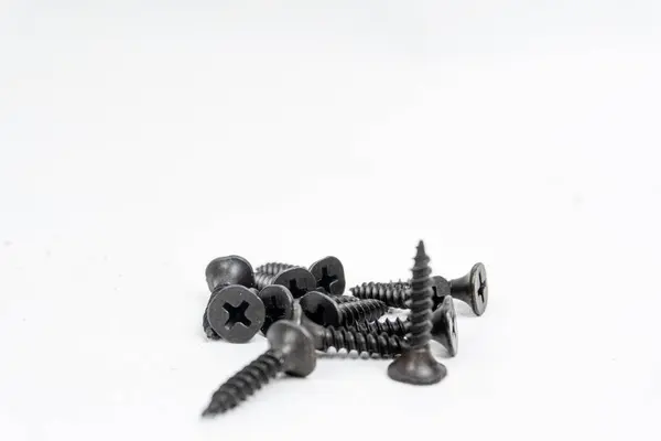 Beyaz arkaplanda izole edilmiş yapı malzemeleri için siyah cıvatalar ve vida yığınları