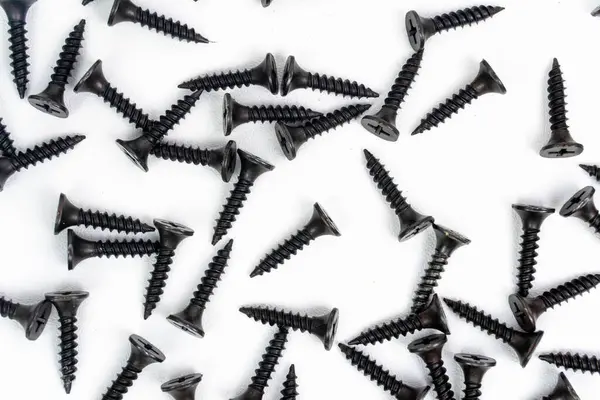 Beyaz arkaplanda izole edilmiş yapı malzemeleri için siyah cıvatalar ve vida yığınları