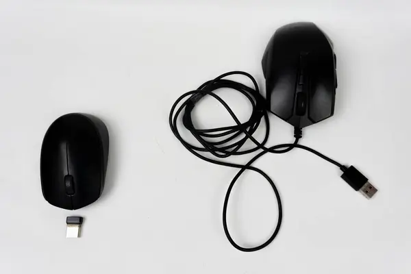 İki siyah bilgisayar faresi, biri kablosuz, beyaz arka planda alıcıları var.
