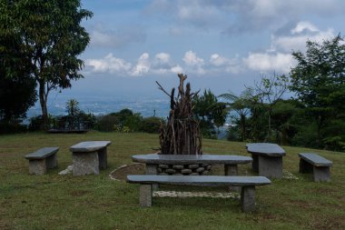 a garden with seating made of concrete, in the middle a bonfire that has not yet been burned clipart