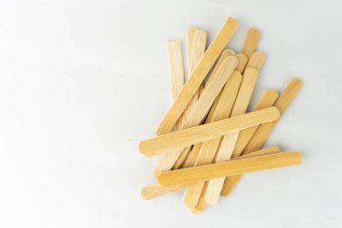 Beyaz arka planda tahta dondurma çubuğu. Bir odun yığını..
