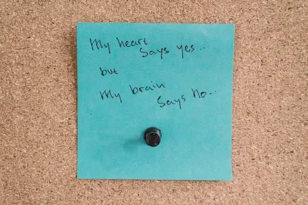 Bir mantar panoya iliştirilmiş mavi yapışkan bir not. Üzerinde 