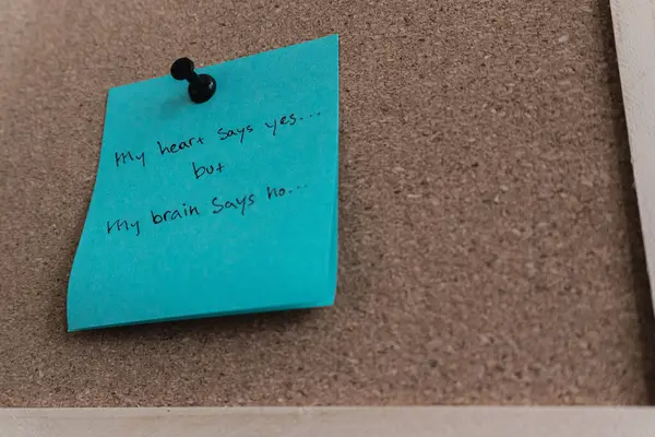 Bir mantar panoya iliştirilmiş mavi yapışkan bir not. Üzerinde 