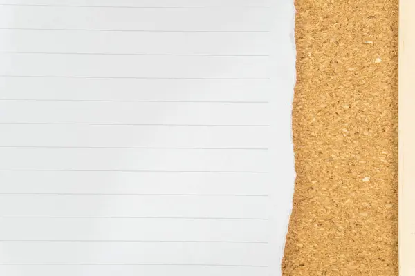 Bir mantar tahtaya karşı yırtılmış kağıt parçası