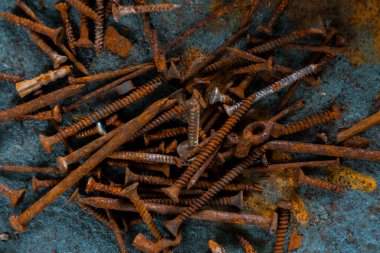 Çelik masada izole edilmiş paslı çivi koleksiyonu.