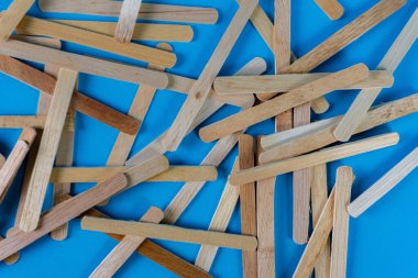 Dağıtılmış ahşap çubuklar ya da mavi arka planda el işi çubukları.