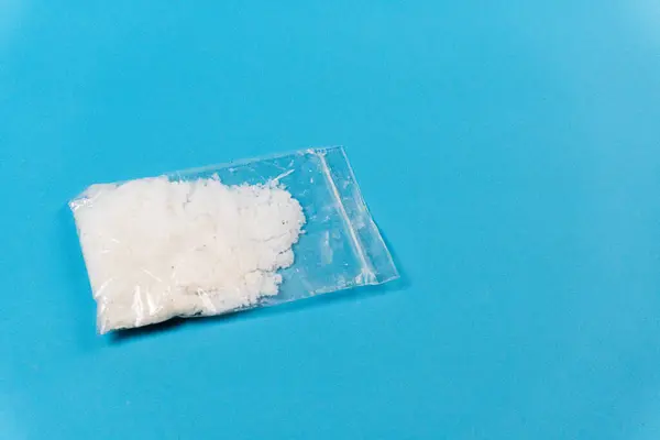 Mavi arka planda beyaz toz ya da meth içeren şeffaf plastik torbalar. Bağımlılık ve kötü alışkanlıklar kavramı.