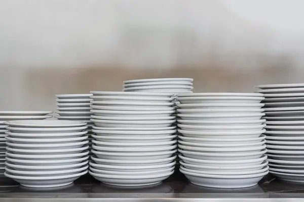 Temiz, beyaz tabakalar düz bir arkaplan ile metal bir rafta düzgünce düzenlenir..